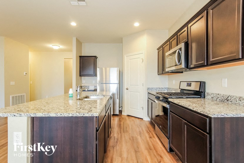 a kitchen with a counter top and a stove and a refrigerator