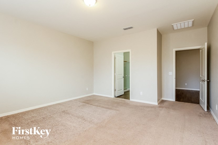 an empty living room with a door to a bathroom