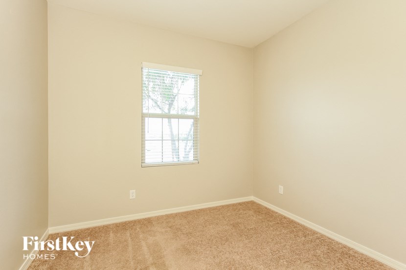 a bedroom with a window and a carpeted floor