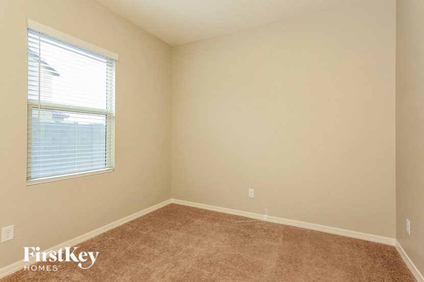 an empty room with a window and a carpet