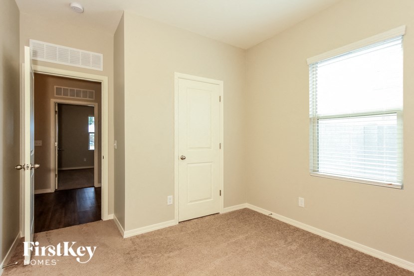 a bedroom with a closet and a door and a window