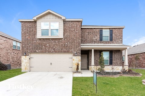 a brick house with a white garage door in front of a lawn