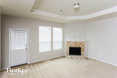 the living room of a new home with a fireplace and a door