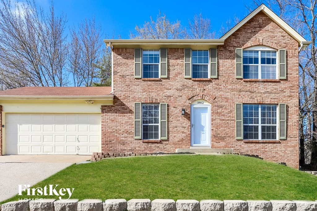 A brick house with a white door and windows.