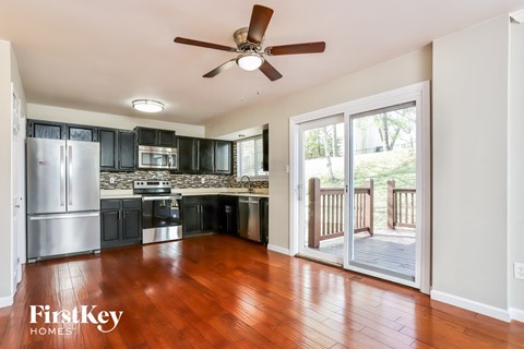 A kitchen with a refrigerator, microwave, oven, and sink.