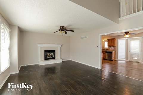 a living room with a fireplace and a ceiling fan