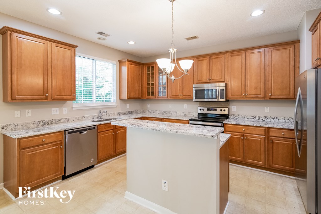 a kitchen with wooden cabinets and a white counter top