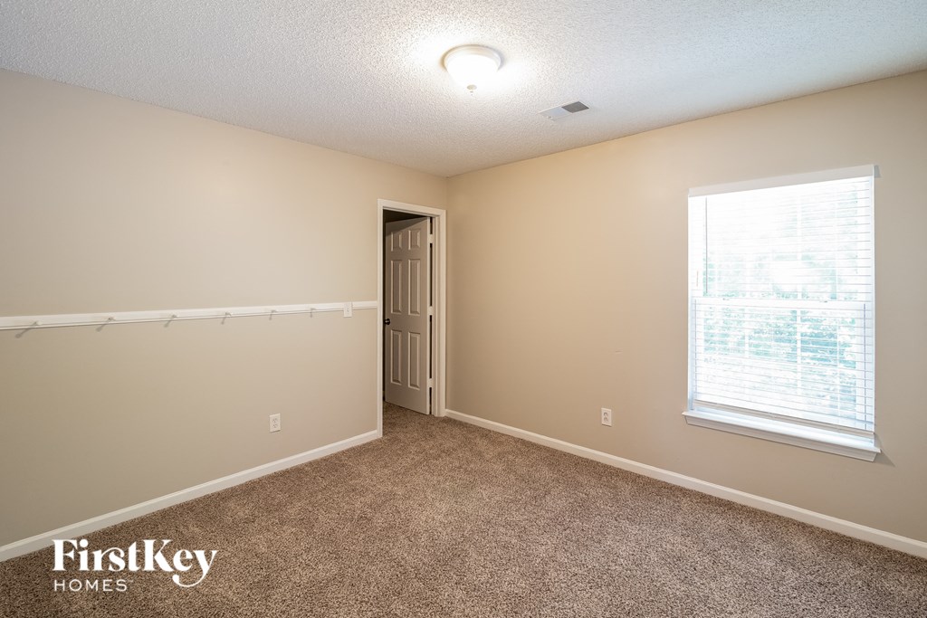 a bedroom with carpet and a door to a closet