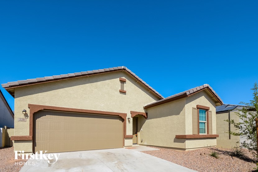 A beige house with a brown garage door and a small window on the side.