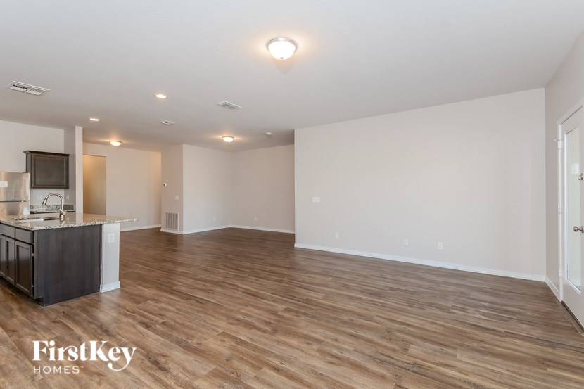 A spacious room with wooden flooring and a kitchen island.