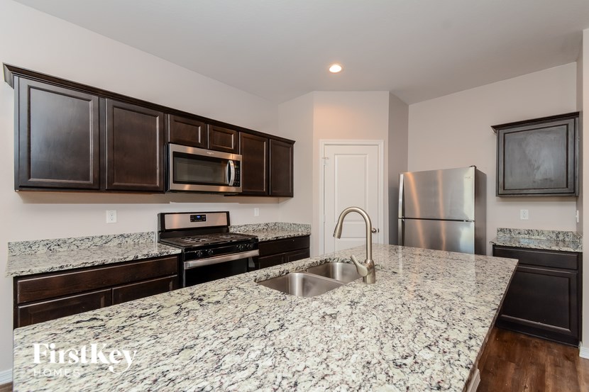 A kitchen with granite countertops and stainless steel appliances.