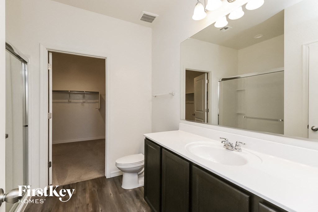 A bathroom with a white sink and a toilet.