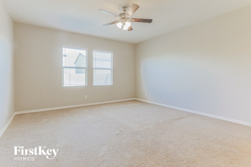 the living room of an empty house with a ceiling fan
