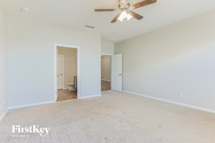 the living room of an empty house with a ceiling fan