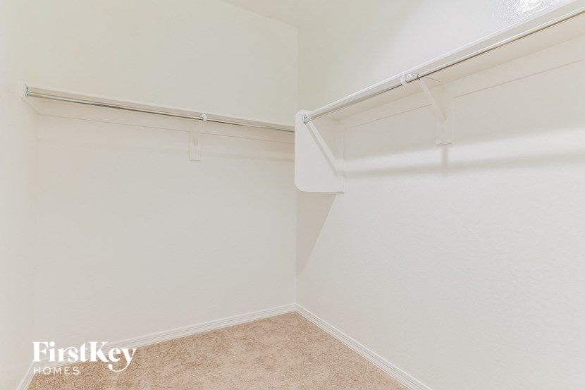 a walk in closet in a white room with a white wall and a white closet