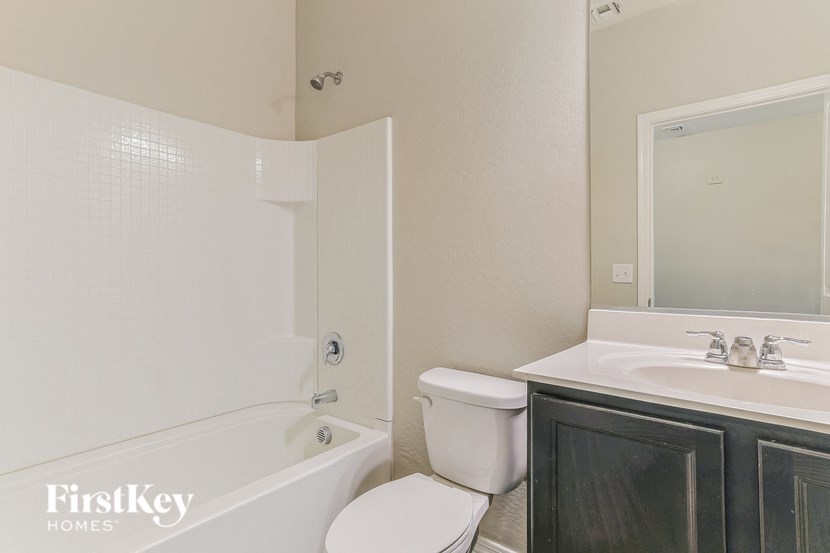 a bathroom with a toilet sink and tub and a mirror