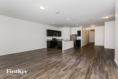 A spacious kitchen with wooden floors and modern appliances.