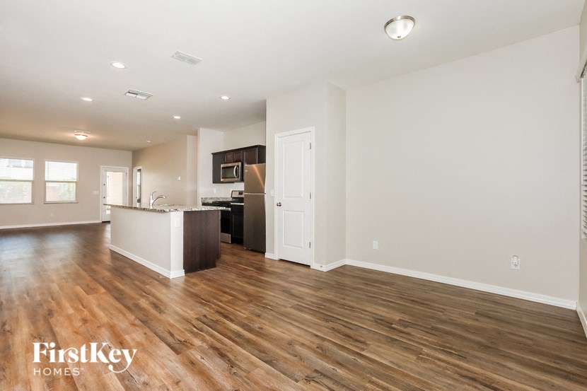 a kitchen and living room with wood flooring in an empty house