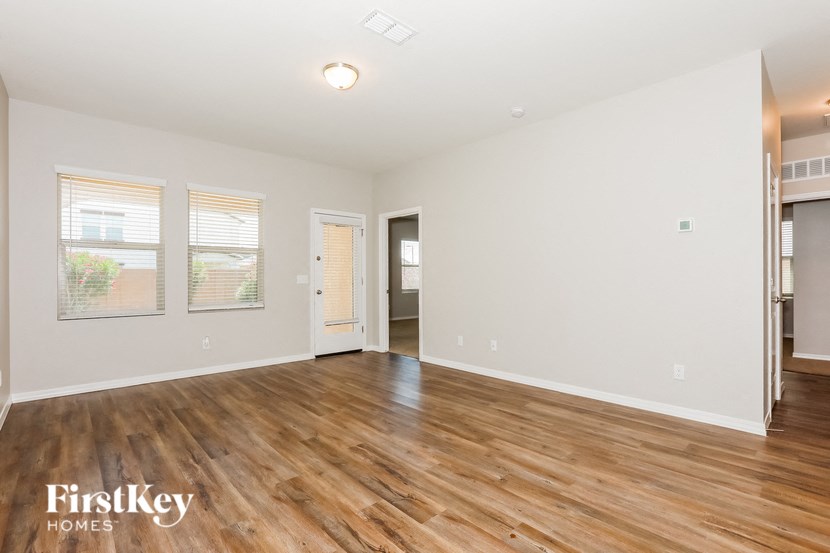 a living room with a hard wood floor and white walls