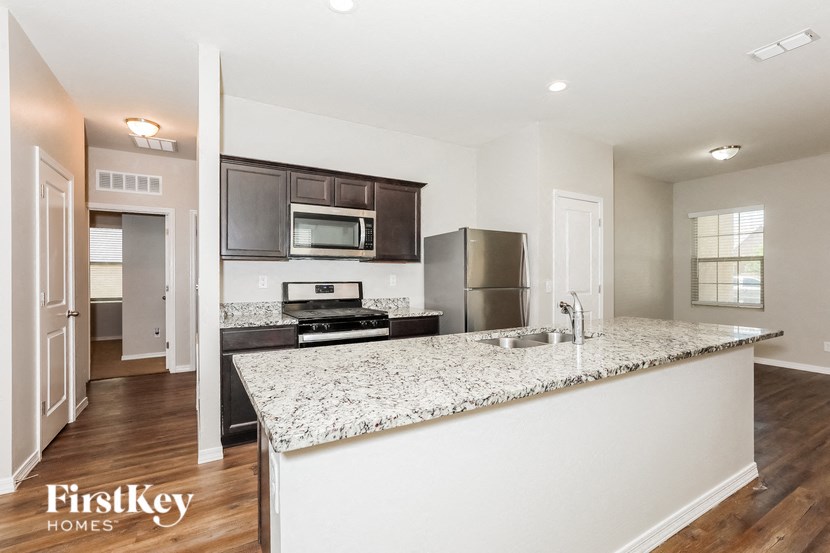 a kitchen with a granite counter top and a stainless steel refrigerator