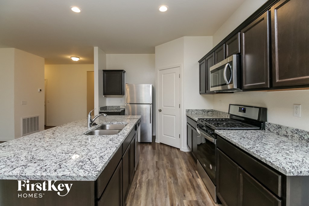 a kitchen with granite counter tops and stainless steel appliances