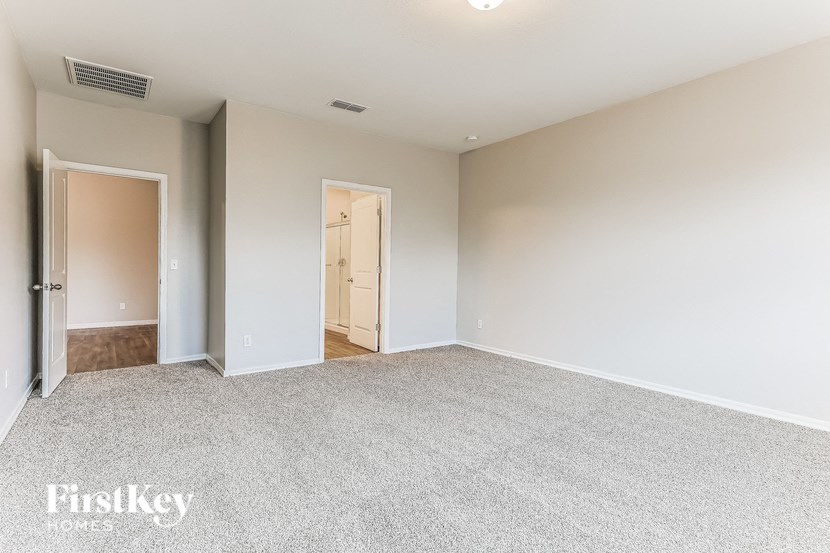 a spacious living room with carpet and white walls