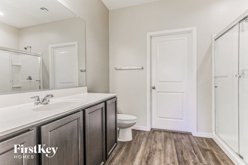 a bathroom with a toilet sink and mirror and a shower