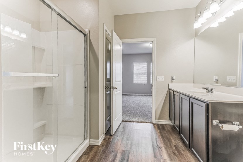 a bathroom with a shower and a sink and a mirror