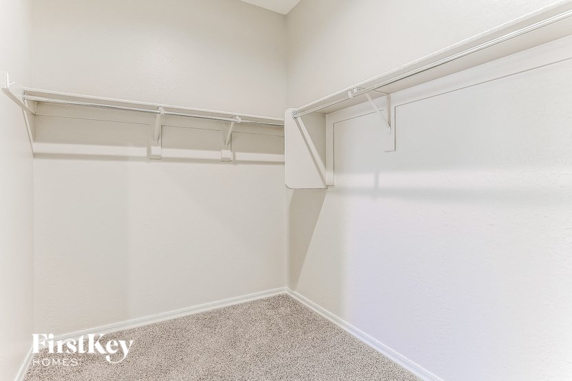 the spacious closet in the master bedroom of a manufactured home with white walls