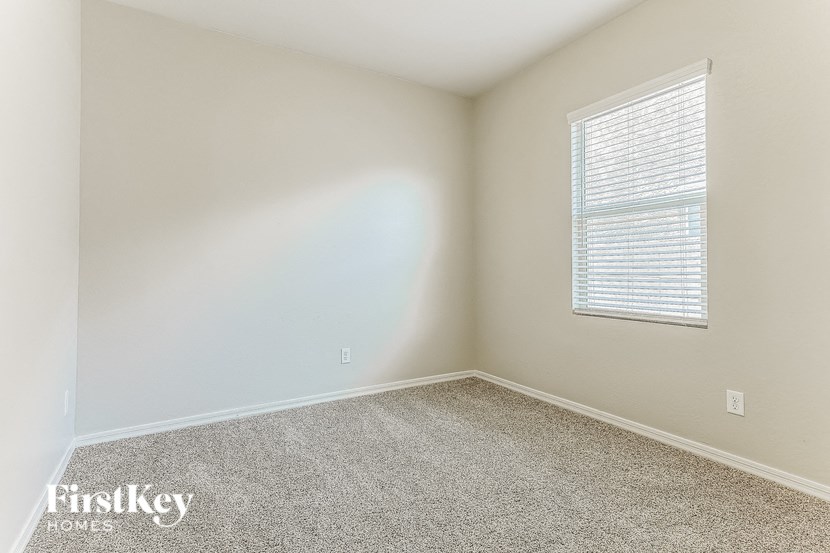 an empty room with a window and carpet