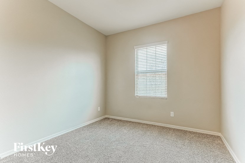 an empty room with white carpet and a window