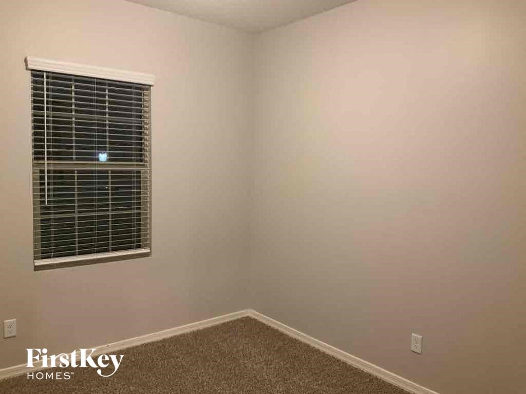 a small room with a window and a carpet