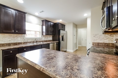 a kitchen with dark wood cabinets and granite counter tops