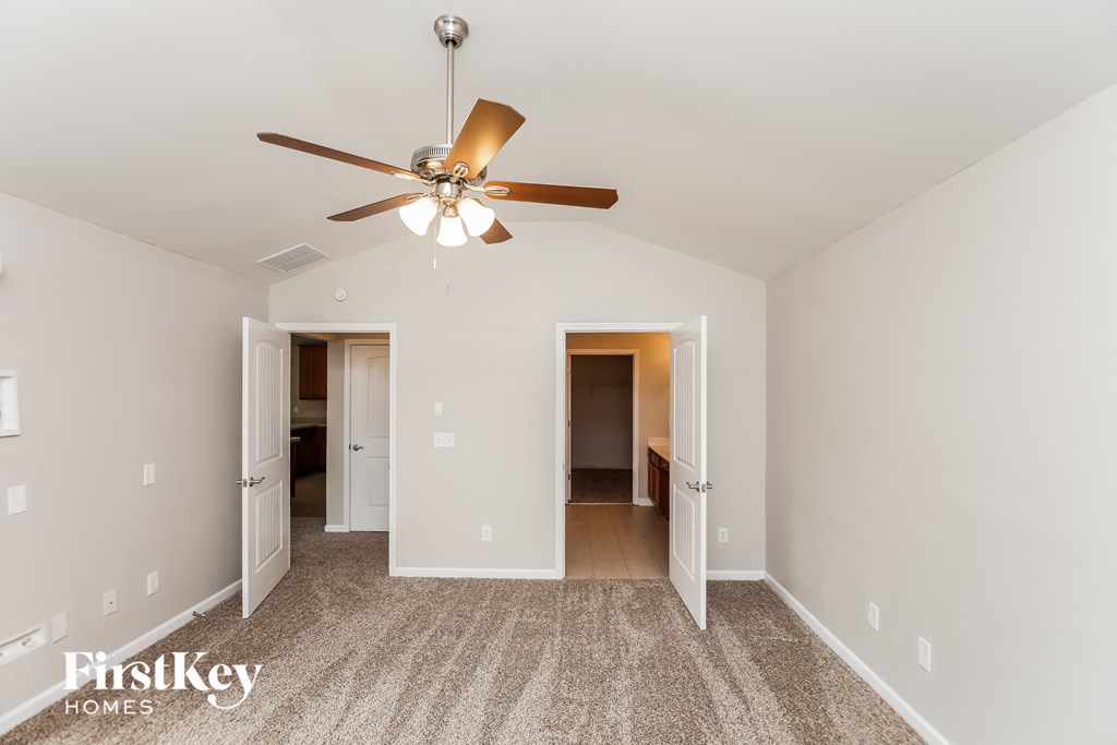 a living room with a ceiling fan and a closet