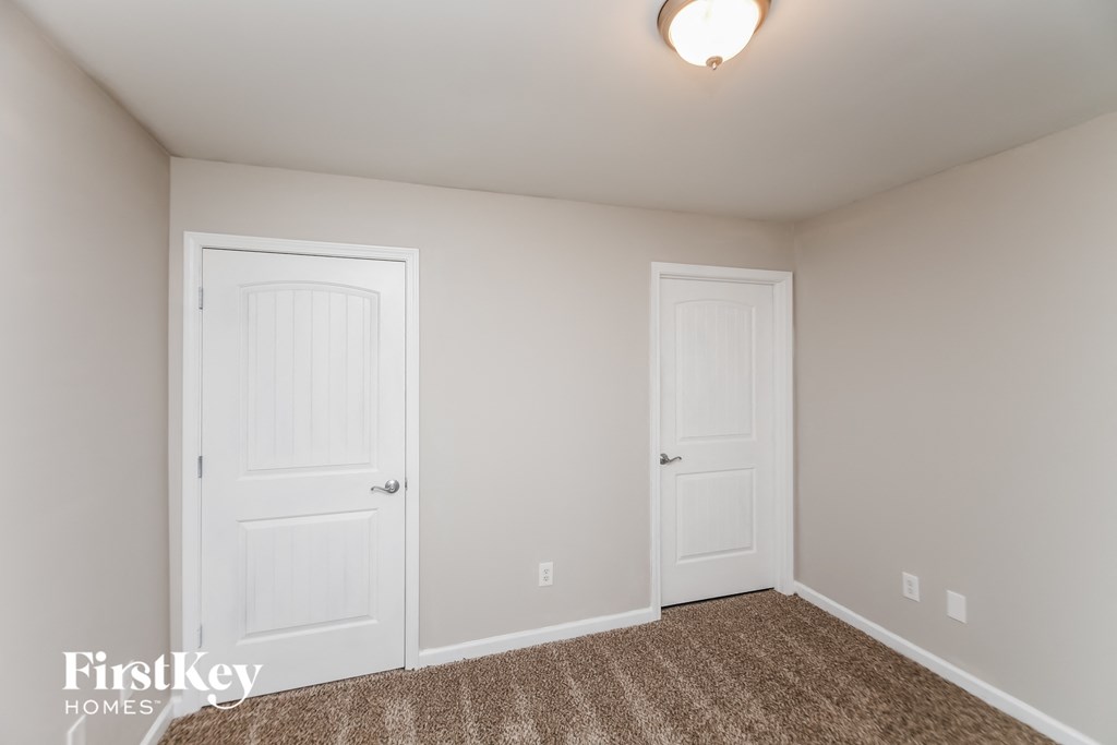 a bedroom with two white doors and a carpeted floor