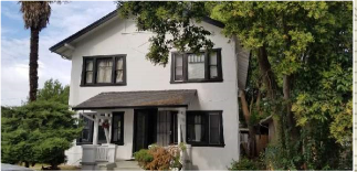 a white house with black windows and trees