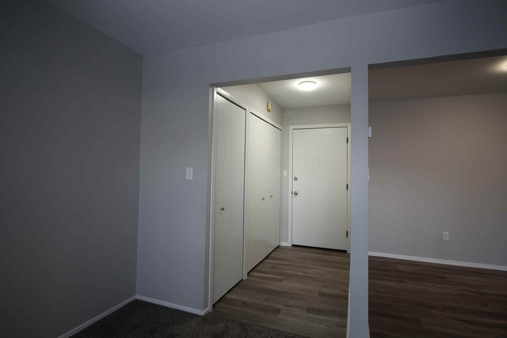 A room with a white door and a white wall.