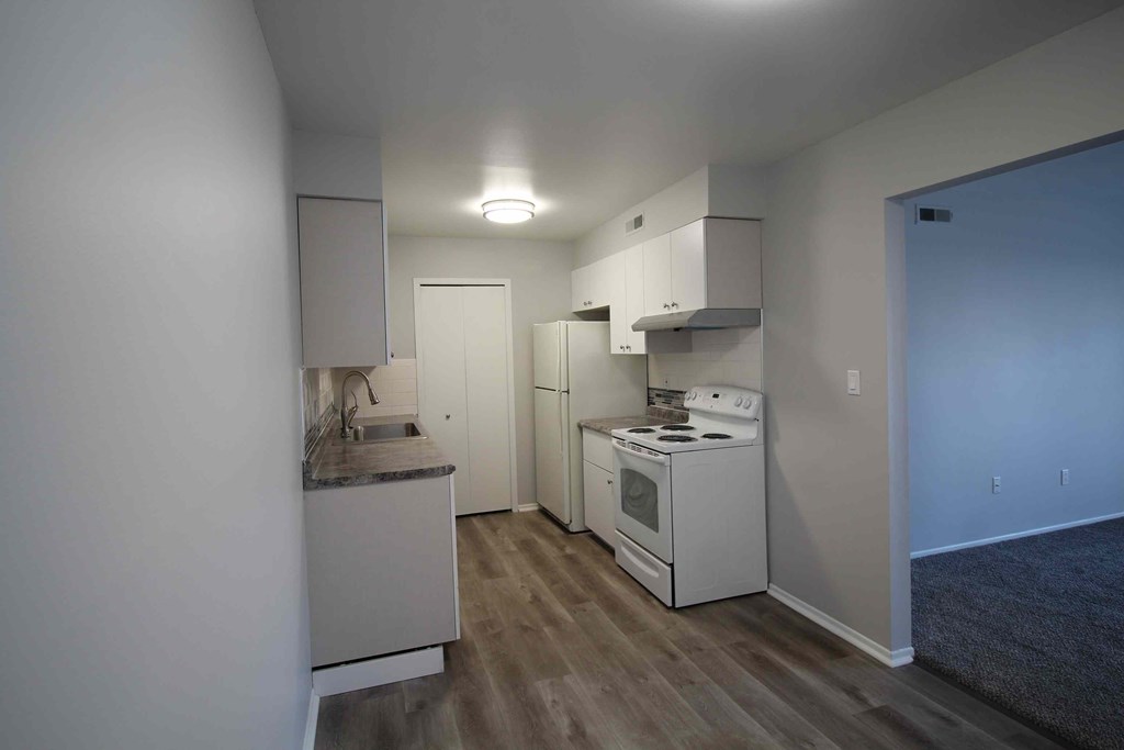 A small kitchen with white appliances and cabinets.