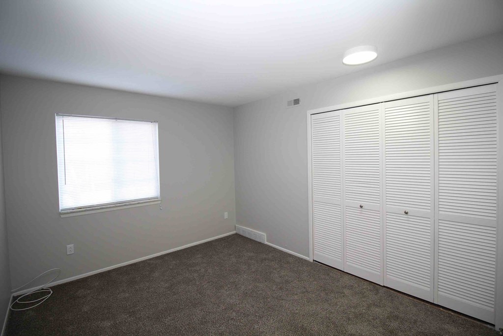 A room with a window and a wall-mounted closet.