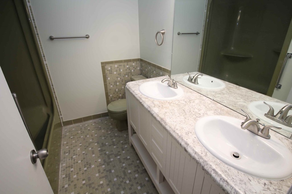 A bathroom with a toilet, sink, and shower.