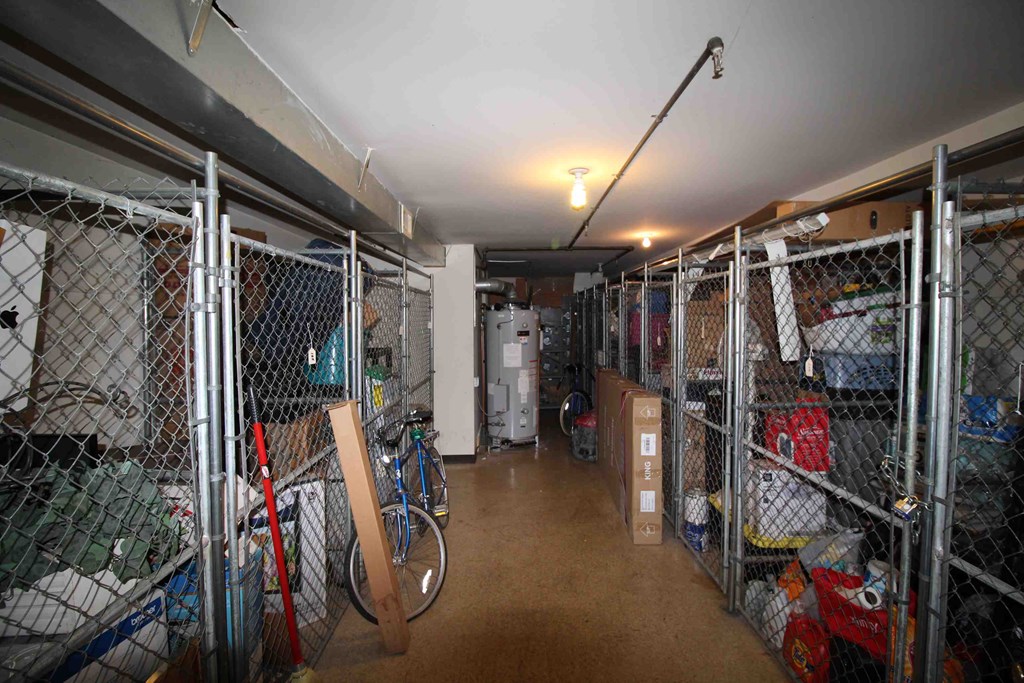 A storage room with a bicycle leaning against a fence.