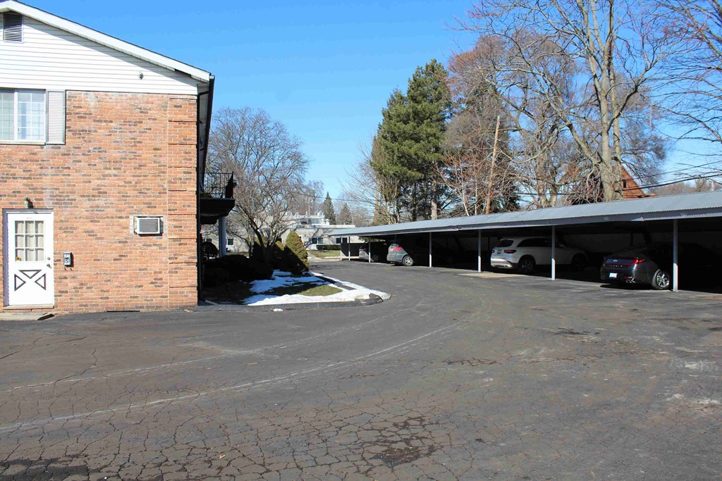 A parking lot with a building and cars.