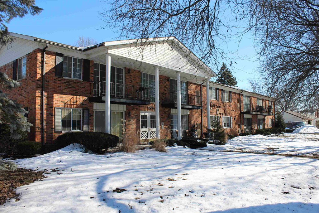 A row of red brick houses with snow on the ground.