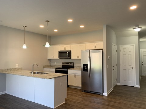 a kitchen with white cabinets and a stainless steel refrigerator
