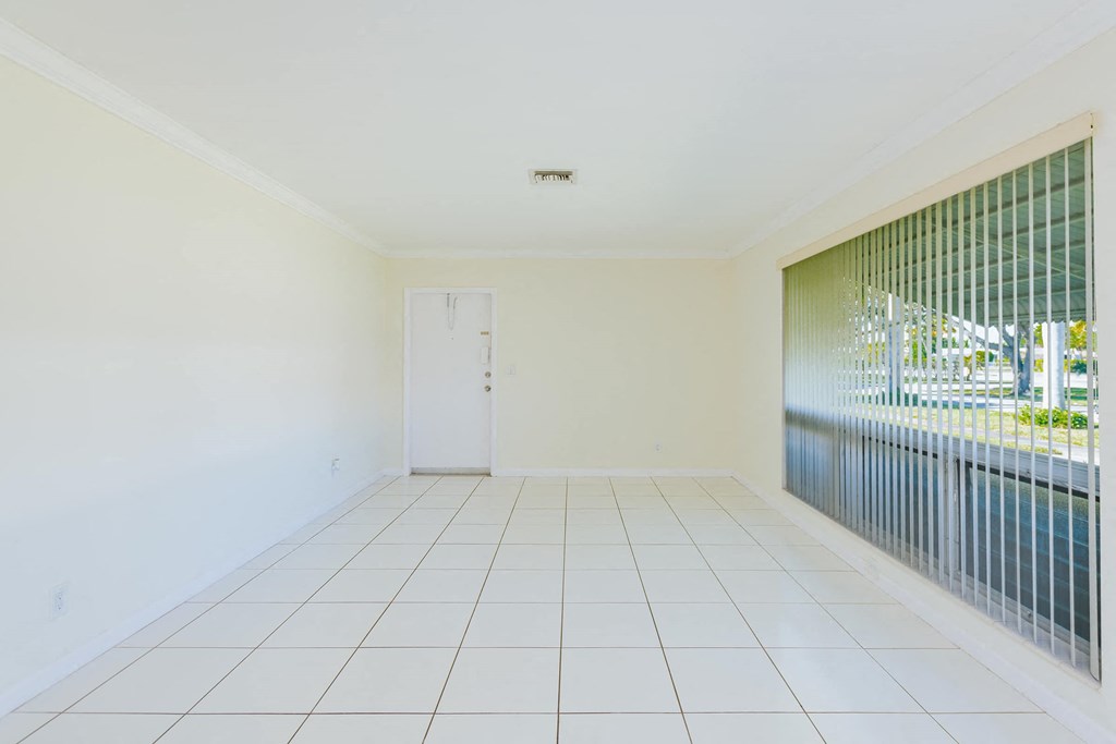 a room with a white tiled floor and a large window