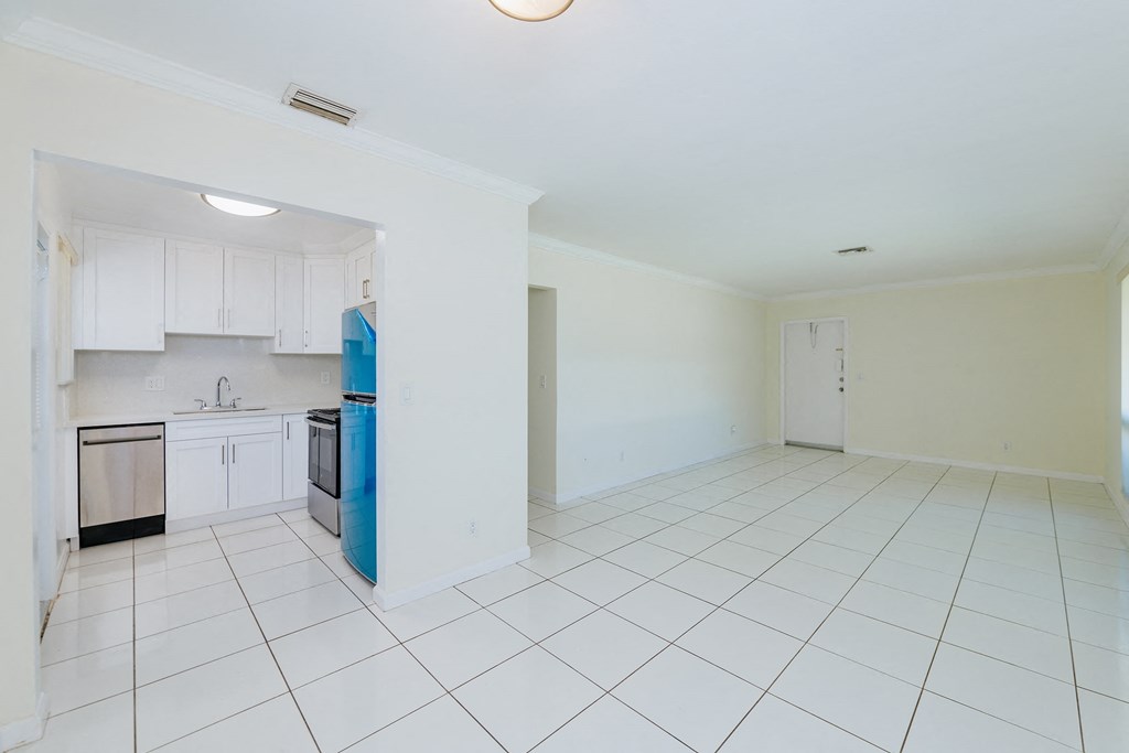 an empty kitchen with white tiles and a blue