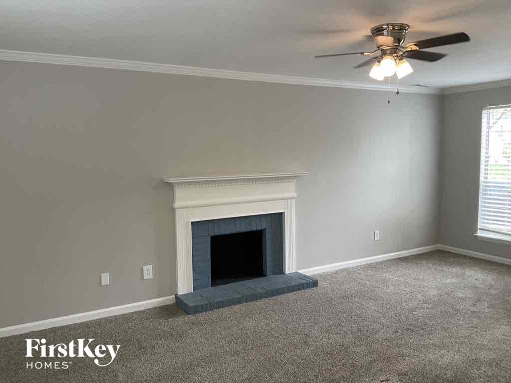 A room with a fireplace and a ceiling fan.