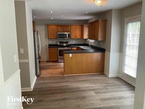 A kitchen with wooden cabinets and a black countertop.