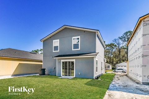 a blue house with a driveway and a yard with grass
