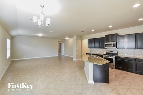A kitchen with black cabinets and a granite countertop.